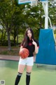 A woman holding a basketball on a basketball court.